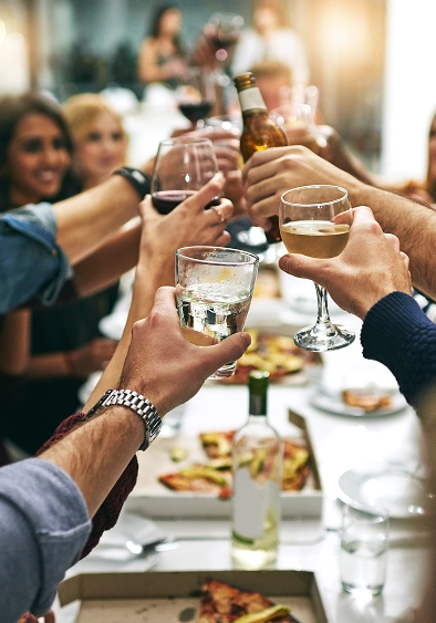 People toasting with drinks at party.